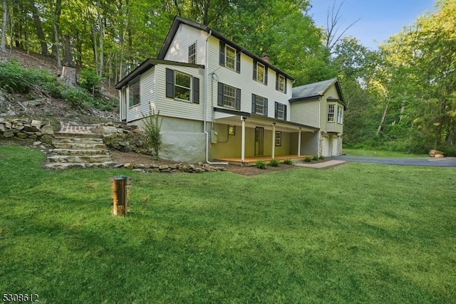 rear view of house featuring a garage and a yard