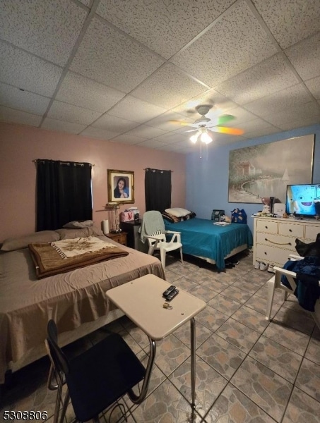 bedroom featuring a drop ceiling and light tile patterned floors