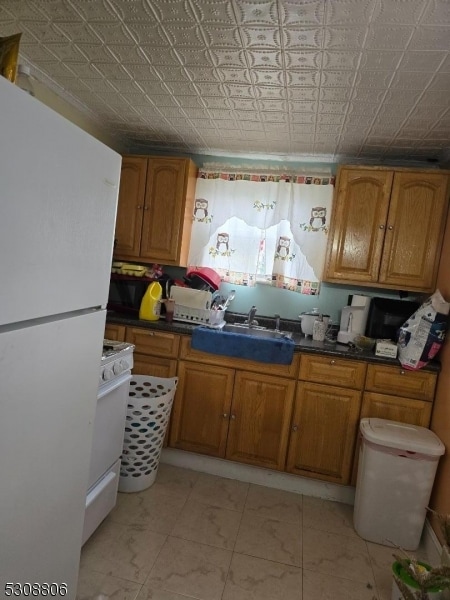 kitchen with sink, white appliances, and light tile patterned flooring