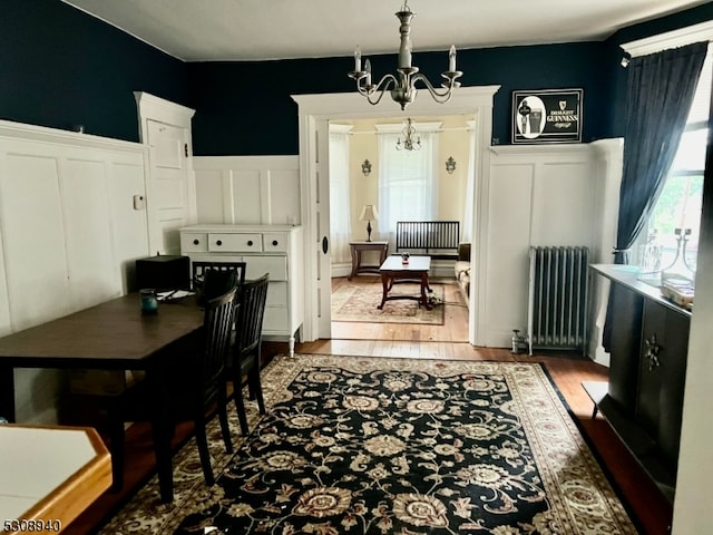 interior space with wood-type flooring, radiator heating unit, and a chandelier