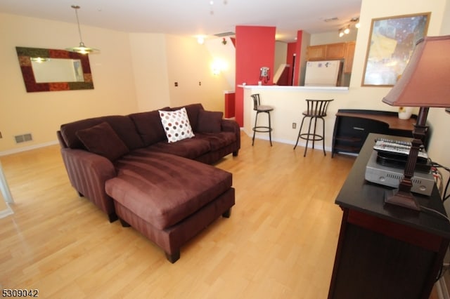 living room featuring ceiling fan and light hardwood / wood-style flooring