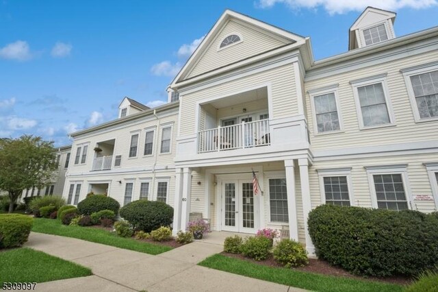 townhome / multi-family property with a balcony and french doors