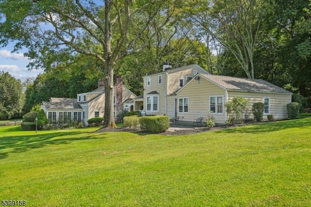 rear view of house featuring a yard