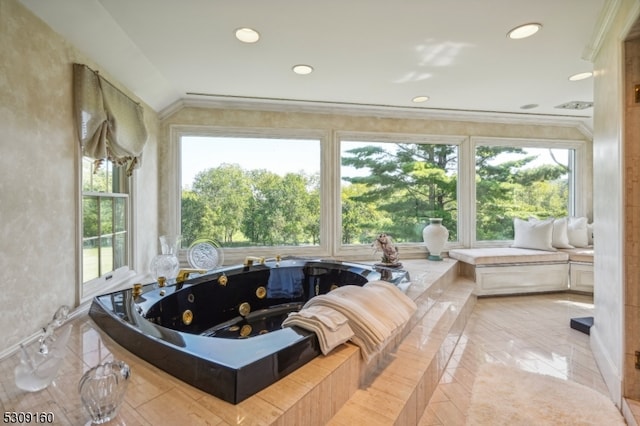 bathroom with a bathing tub, a healthy amount of sunlight, and crown molding