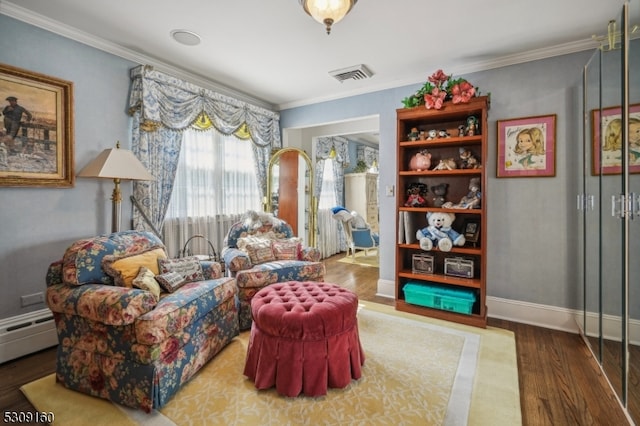 sitting room featuring a baseboard heating unit, hardwood / wood-style flooring, and crown molding