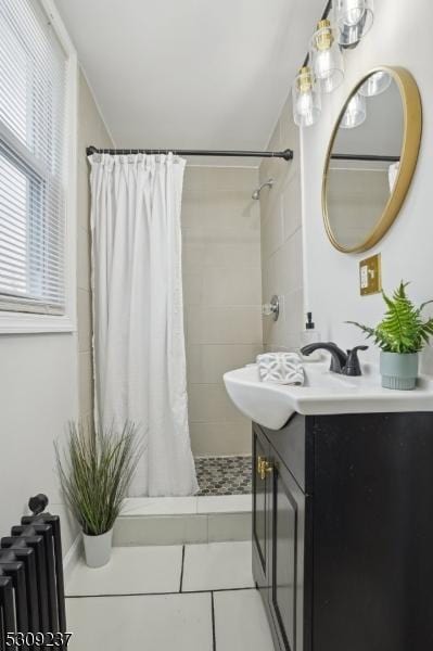 bathroom with a stall shower, tile patterned flooring, vanity, and radiator heating unit