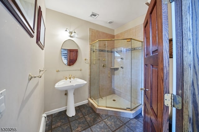 bathroom with a shower with door, a baseboard radiator, and tile patterned flooring