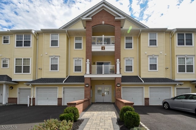 view of property featuring a garage and a balcony