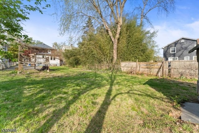 view of yard featuring fence and a deck