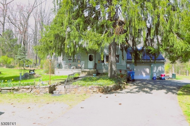 view of property hidden behind natural elements with covered porch