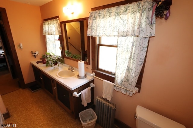 bathroom featuring toilet, radiator, and vanity