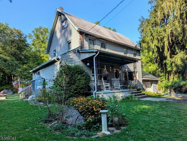 back of house featuring a porch and a lawn