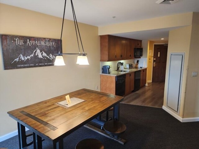 dining area featuring dark wood-type flooring and sink