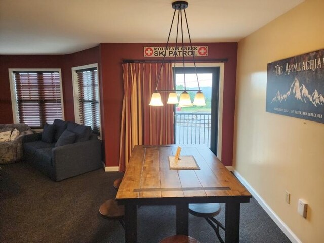 carpeted dining area featuring a chandelier