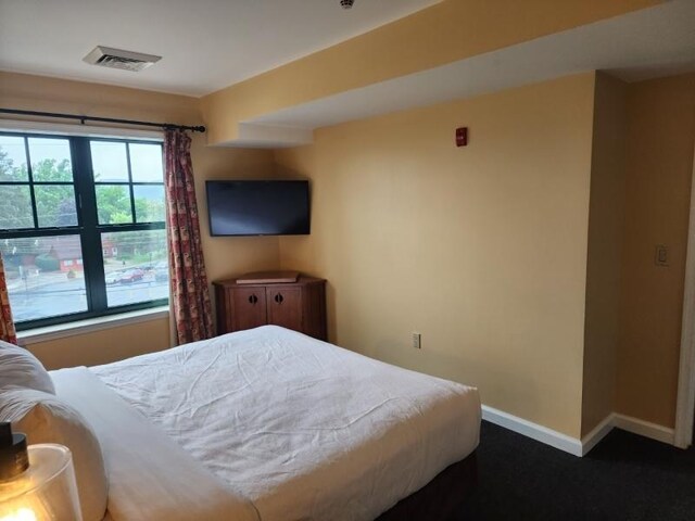 bedroom featuring dark carpet