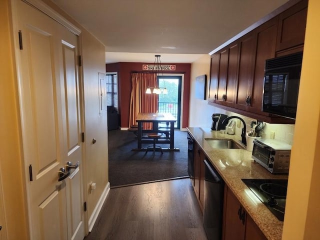 kitchen with dark wood-style floors, hanging light fixtures, a sink, light stone countertops, and black appliances