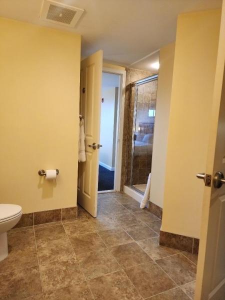 full bathroom with toilet, a shower stall, visible vents, and baseboards