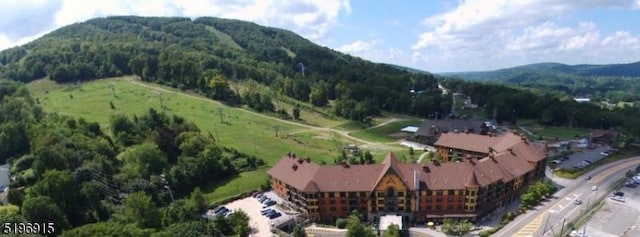 aerial view featuring a wooded view and a mountain view