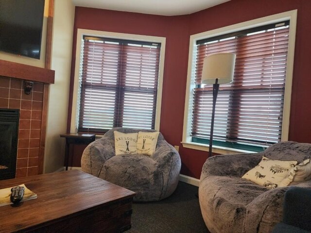 living room featuring a tiled fireplace and carpet