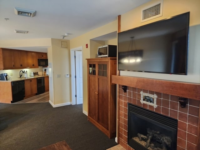 carpeted living room with a fireplace and sink