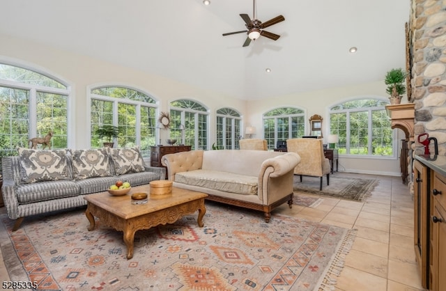 living room with a healthy amount of sunlight, ceiling fan, light tile patterned floors, and a fireplace