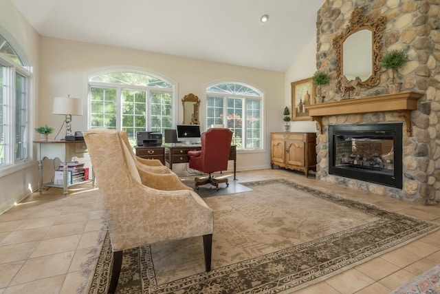 living area with vaulted ceiling, a fireplace, light tile patterned flooring, and a healthy amount of sunlight