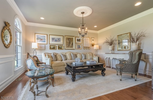 living room with ornamental molding, wood-type flooring, and a notable chandelier