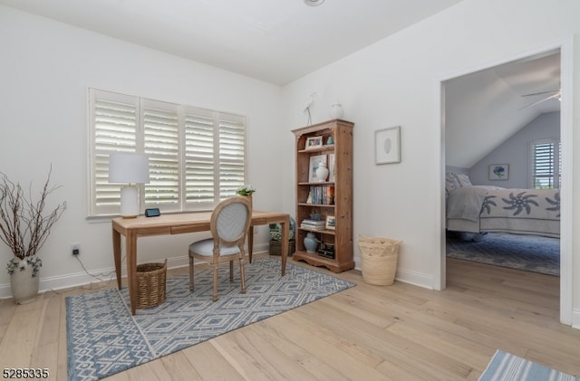 office area featuring lofted ceiling, ceiling fan, and light hardwood / wood-style flooring