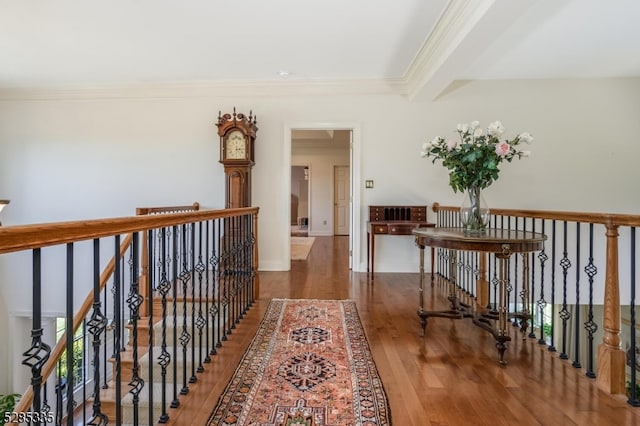 corridor featuring dark wood-type flooring, ornamental molding, and beamed ceiling