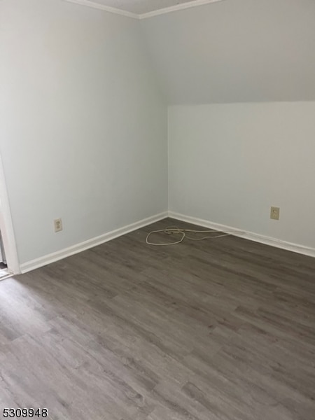 additional living space with dark hardwood / wood-style flooring and vaulted ceiling