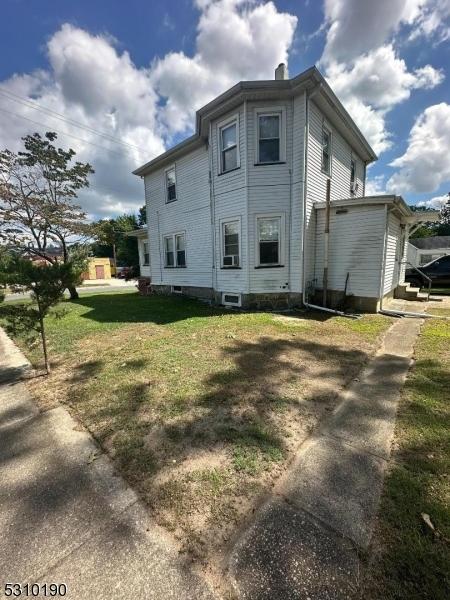 rear view of house with a lawn and a chimney