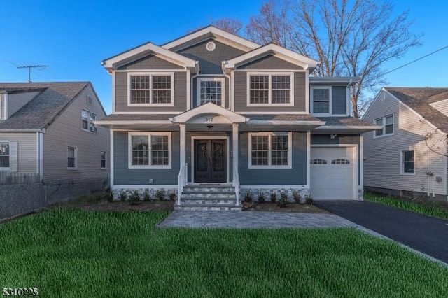 view of front of house featuring aphalt driveway, a garage, and a front yard