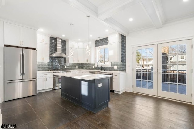 kitchen with beam ceiling, wall chimney exhaust hood, high end appliances, and backsplash