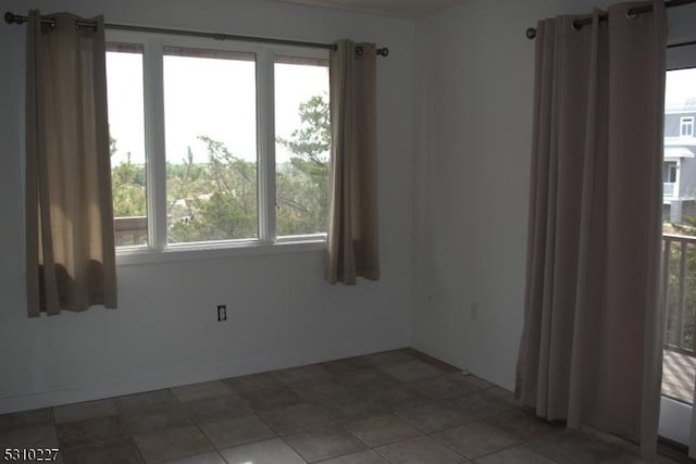 tiled spare room featuring a wealth of natural light