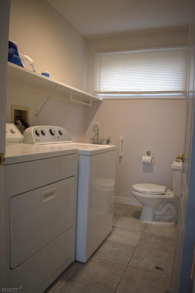 clothes washing area featuring independent washer and dryer and light tile patterned floors