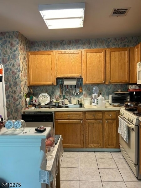 kitchen featuring light tile patterned floors, sink, and white appliances