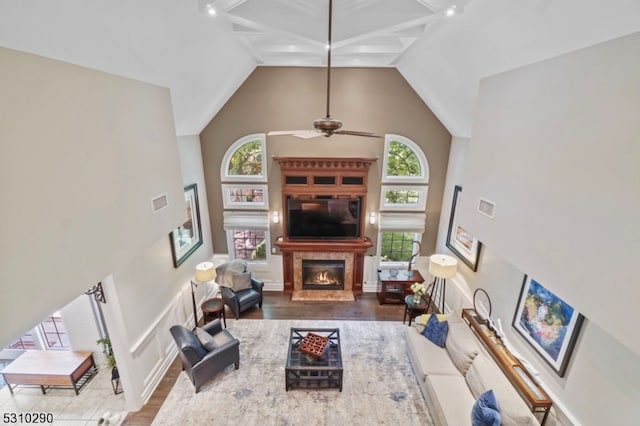 living room featuring ceiling fan, hardwood / wood-style floors, high vaulted ceiling, and beam ceiling