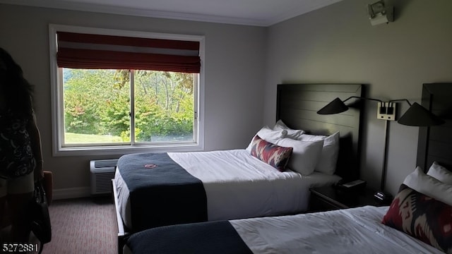 bedroom featuring crown molding and dark carpet