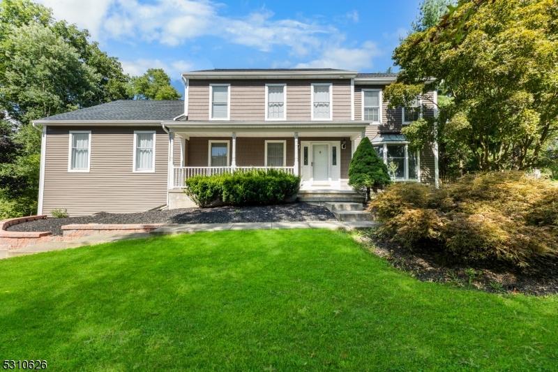 rear view of property with a lawn and covered porch