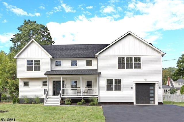 view of front of home with a porch, a garage, and a front lawn