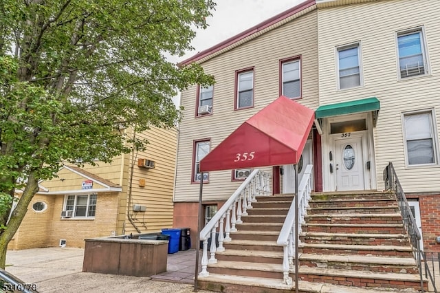 view of front of home with a wall mounted air conditioner