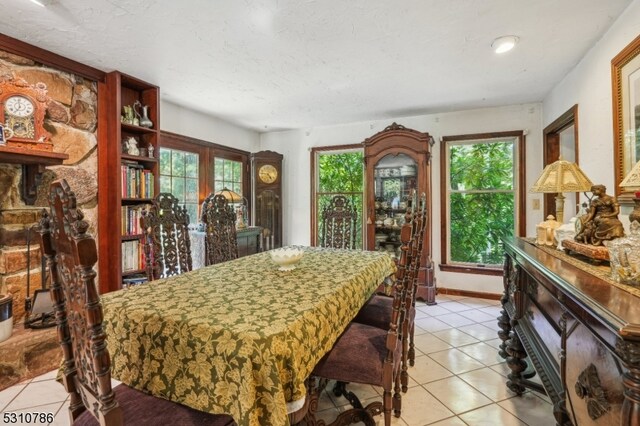 dining room with a textured ceiling, plenty of natural light, and light tile patterned floors