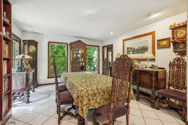 tiled dining room featuring a textured ceiling