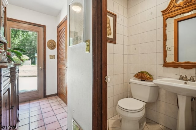 bathroom featuring tile walls, toilet, tasteful backsplash, and tile patterned floors