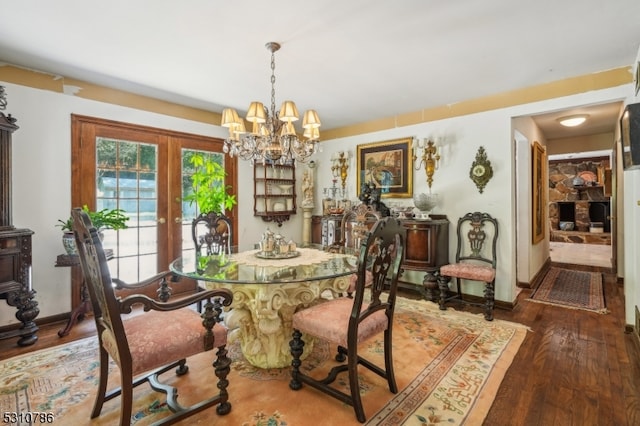 dining space with french doors, a chandelier, and dark hardwood / wood-style flooring