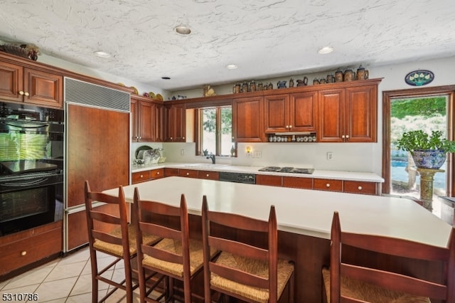 kitchen featuring light tile patterned flooring, sink, and black appliances