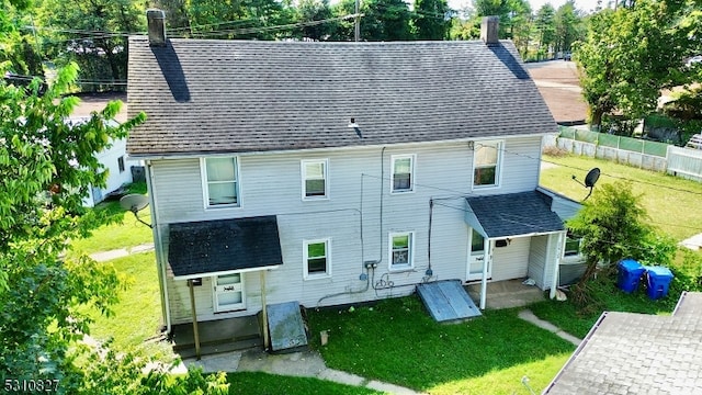 rear view of house featuring a lawn and a patio