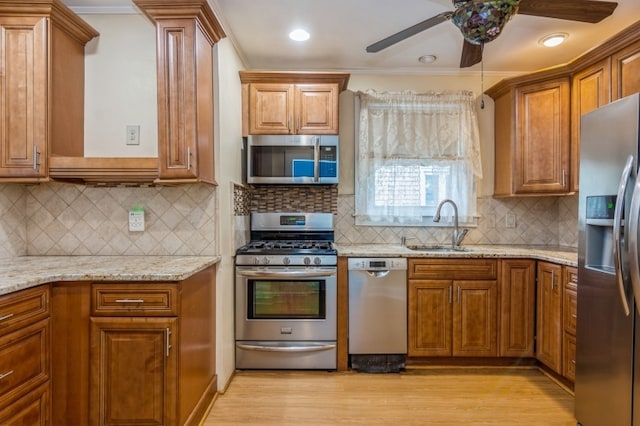 kitchen featuring light stone countertops, sink, stainless steel appliances, tasteful backsplash, and crown molding