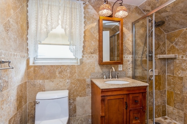 bathroom featuring vanity, toilet, an enclosed shower, and tile walls