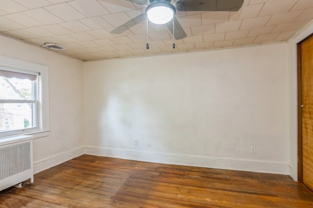 empty room featuring dark hardwood / wood-style floors and radiator